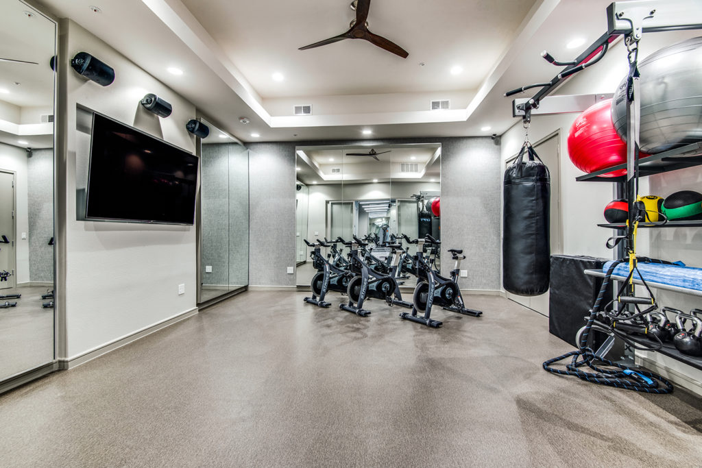 Peloton bike studio with large TV screen and core training equipment