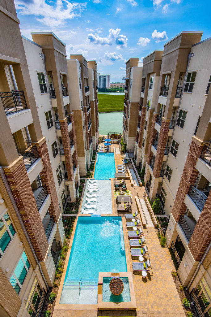 Aerial view of community resort-style pool courtyard and outdoor lounge