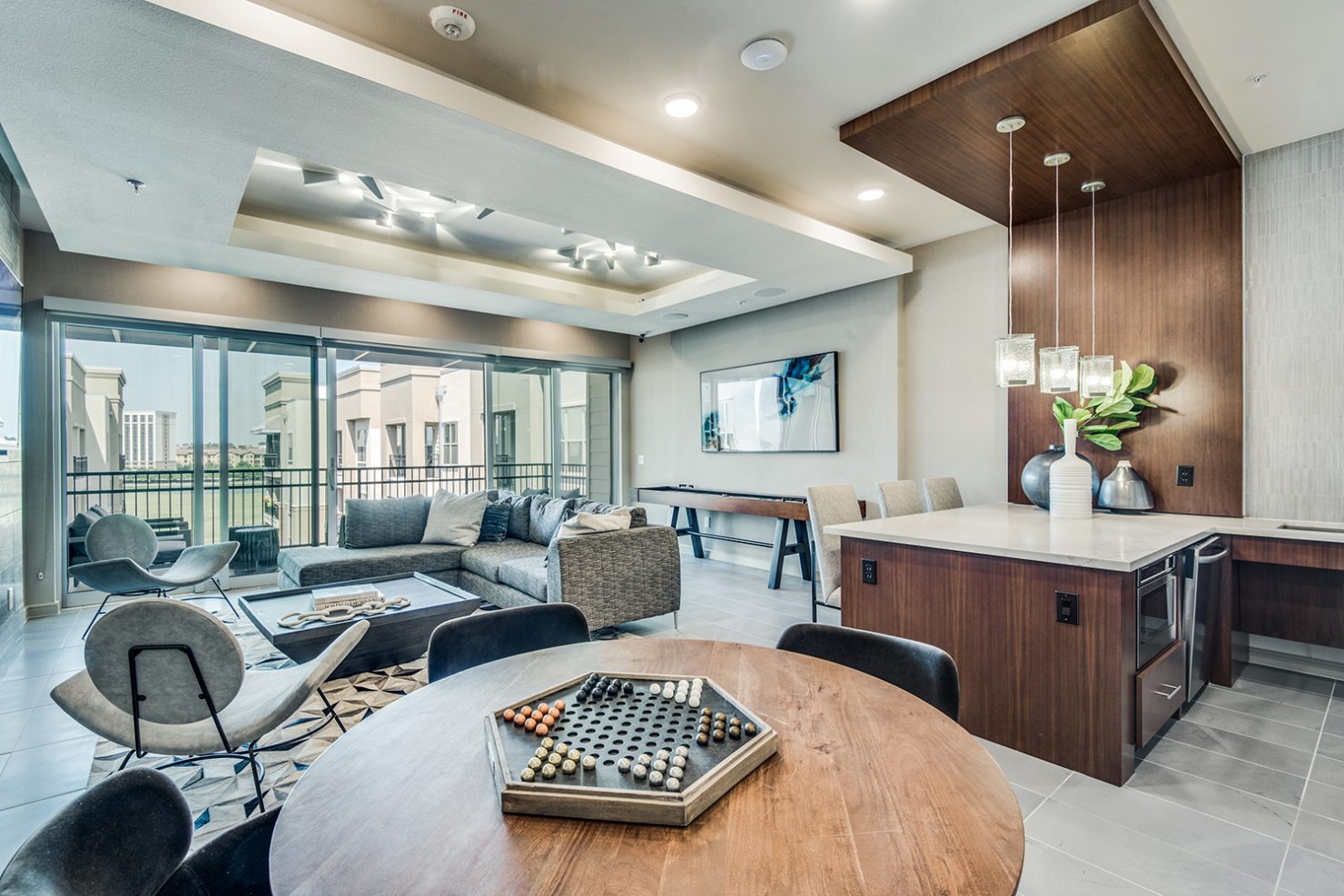 Clubroom with seating area, balcony, shuffleboard, demonstration kitchen, and Chinese checkers